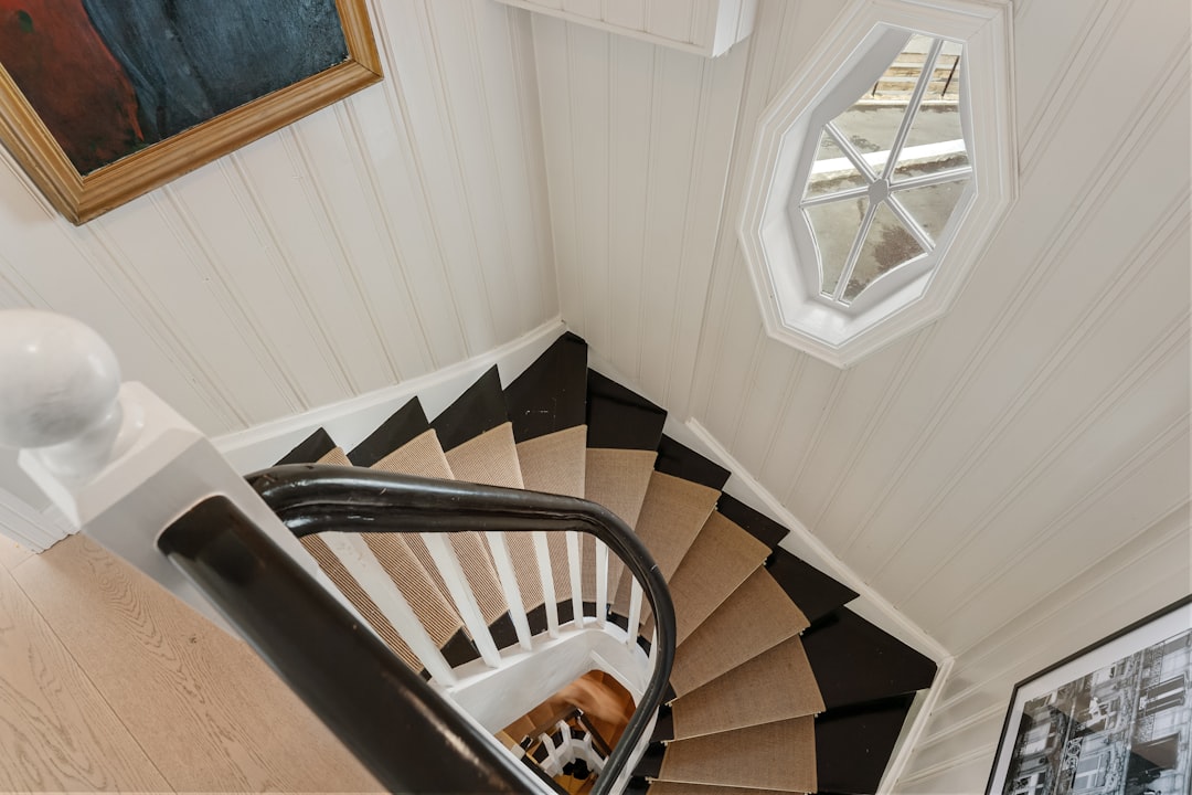 A spiral staircase in a home with a painting on the wall
