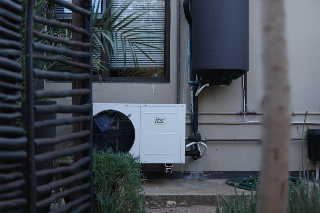 White outdoor air conditioning unit on a building wall.
