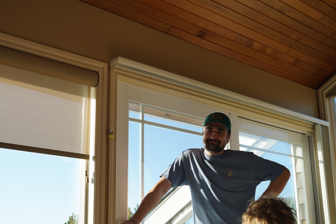 a man standing in front of a window next to a little girl