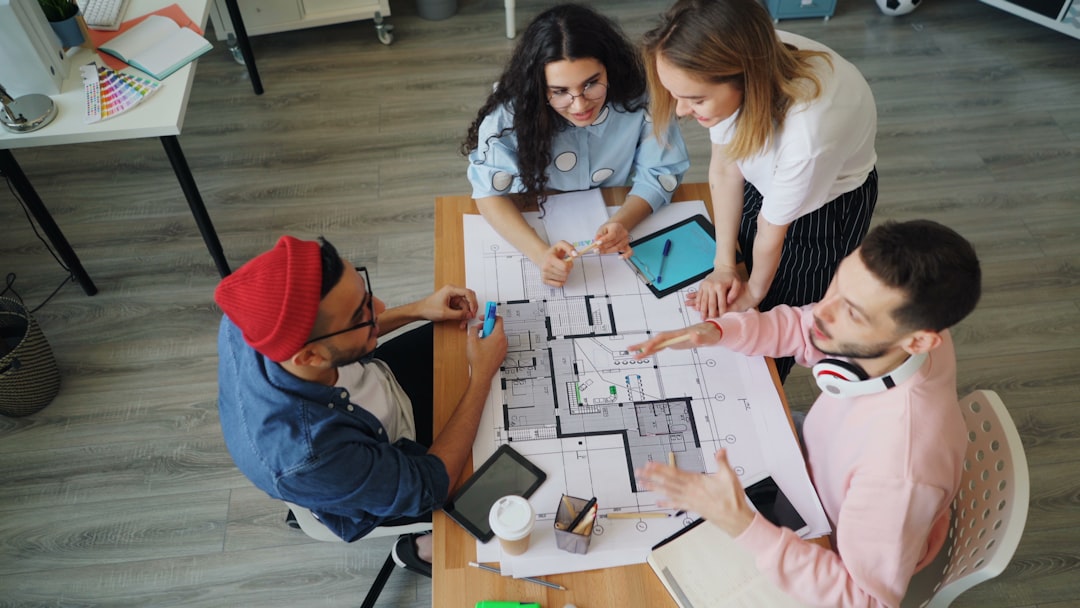 a group of people sitting around a table working on a project