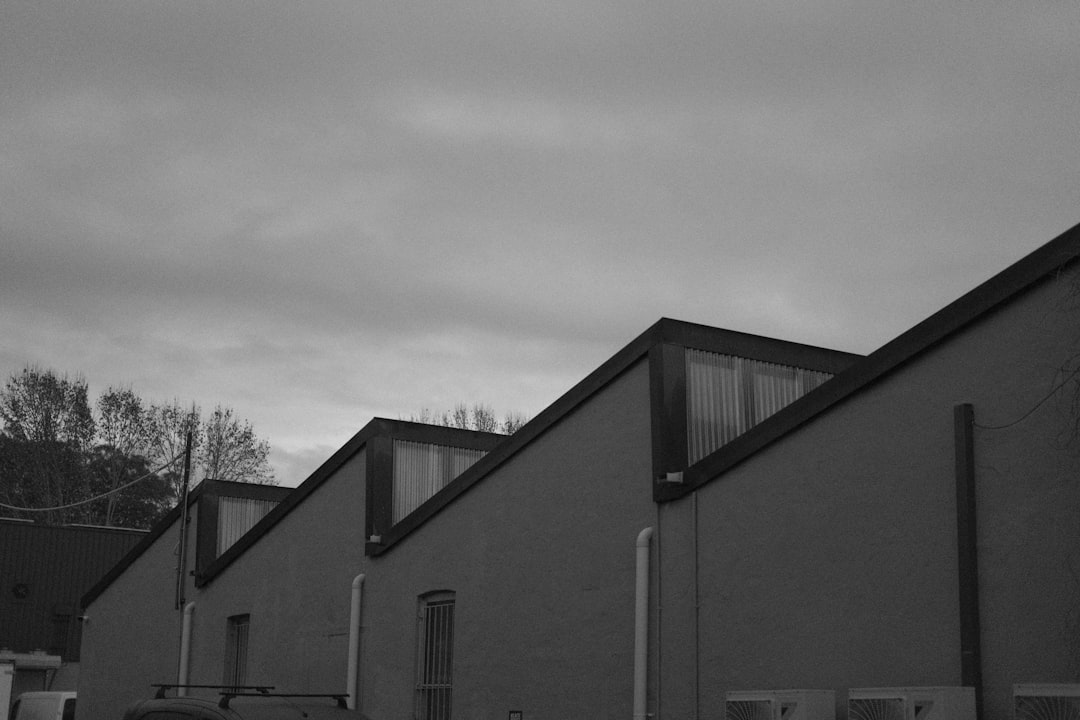 Industrial building with sawtooth roof and skylights under cloudy sky